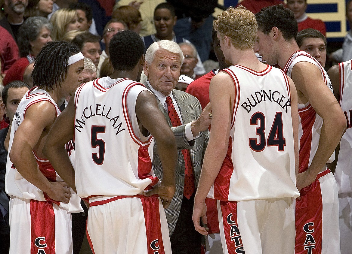 FILE - In this Dec. 20, 2006, file photo, Arizona coach Lute Olson, center, talks to his players, from left, Daniel Dillon, Jawann McClellan (5), Chase Budinger (34) and Ivan Radenovic during the second half of an NCAA college basketball game against Memphis in Tucson, Ariz. Olson, the Hall of Fame coach who turned Arizona into a college basketball powerhouse, has died at the age of 85. Olson’s family said he died Thursday, Aug. 27, 2020. The family did not provide the cause of death. (AP Photo/John Miller, File)