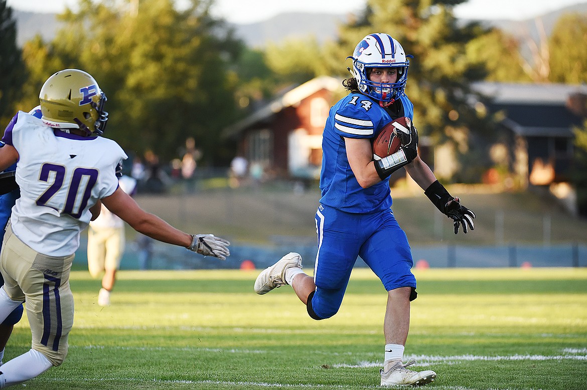 Columbia Falls wide receiver Taylor Bryan (14) looks for room to run after a reception in the first half against Polson at Satterthwaite Memorial Field on Friday. (Casey Kreider/Daily Inter Lake)