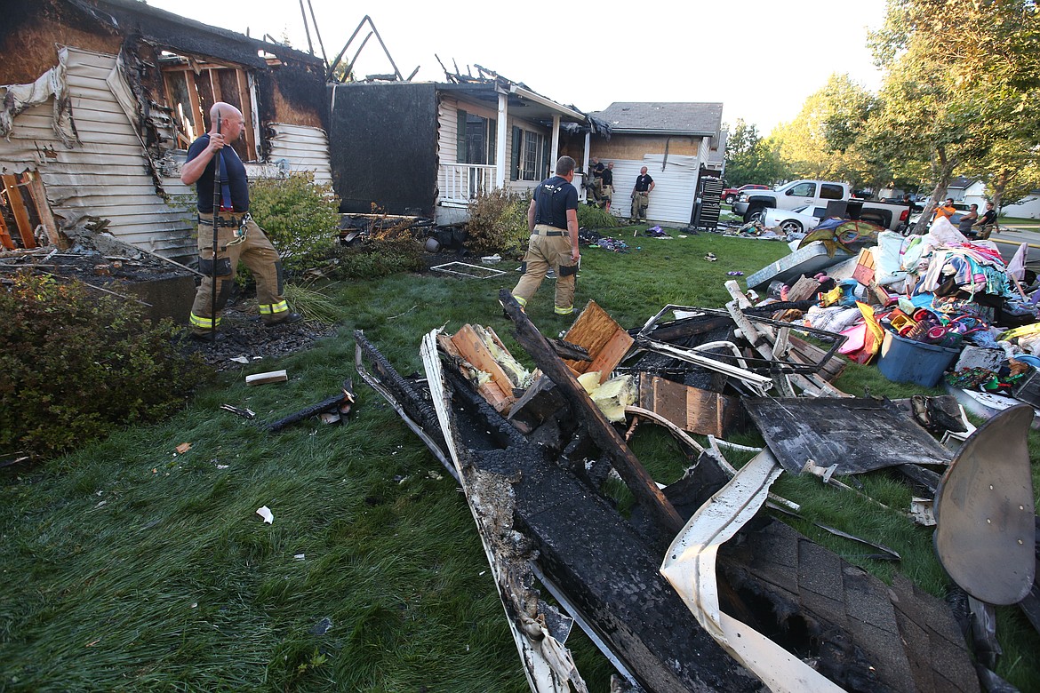 A pile of items pulled from the Post Falls homes lost in the fire Friday rests in the front yard.