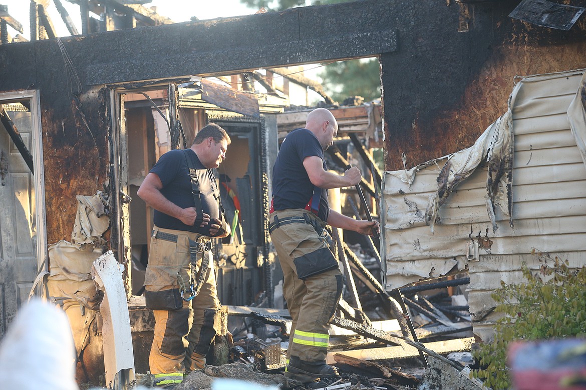 Two firefighters check for hot spots Friday after two Post Falls homes were destroyed in a fire.