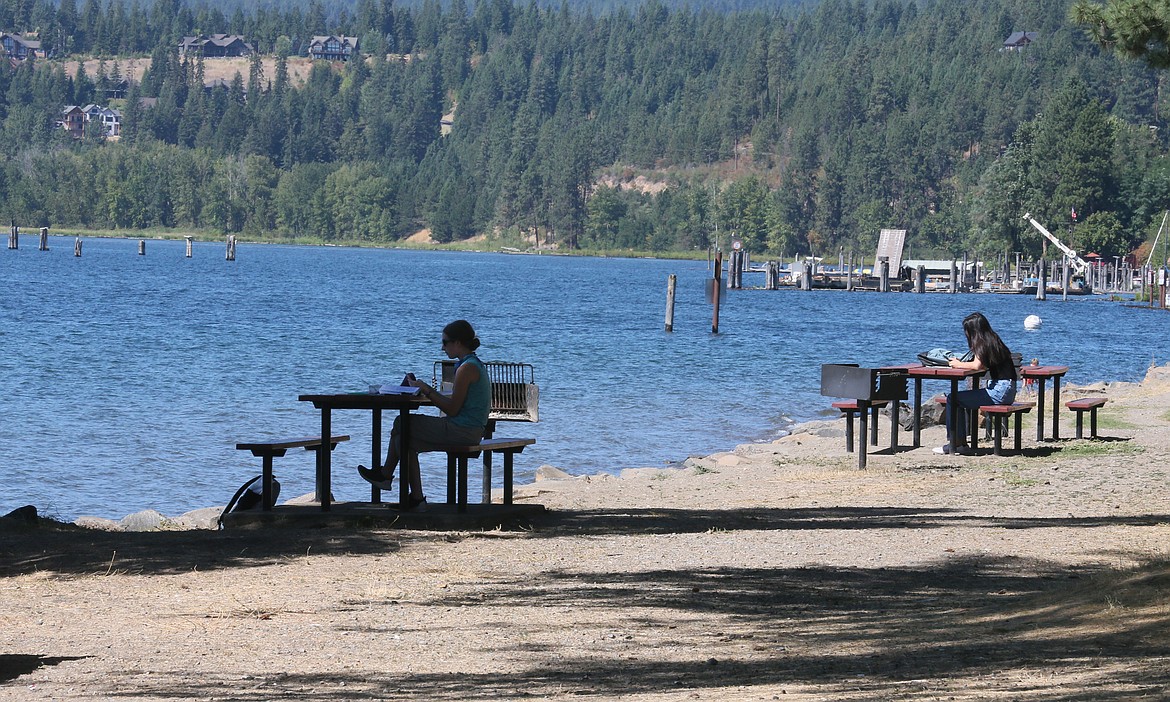 Students independently work at picnic tables on the North Idaho College Beach on Friday. The first week of college has wrapped up, bringing with it a new normal of face masks and social distancing.