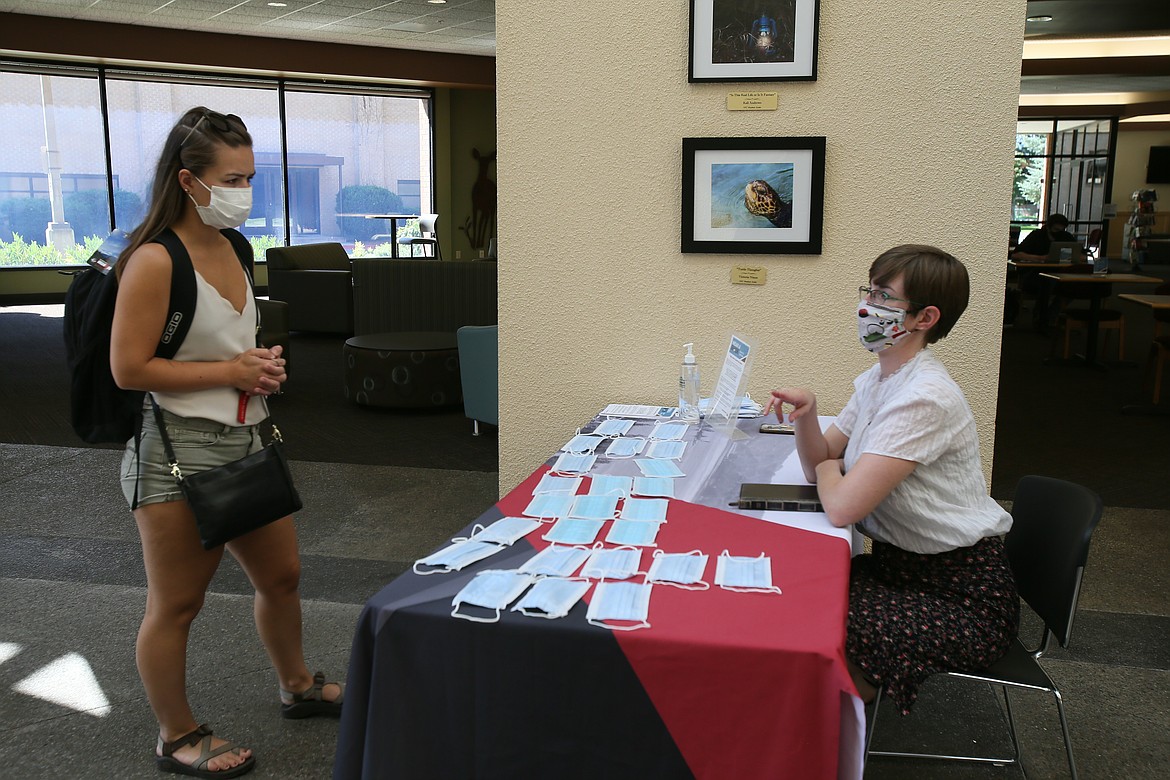 Madelyn Christensen, left, gathers information from NIC's Student Involvement Office administrative assistant Crystal Carney, who gave out masks to students on Friday. "I think this semester will go much smoother than people think," Carney said.