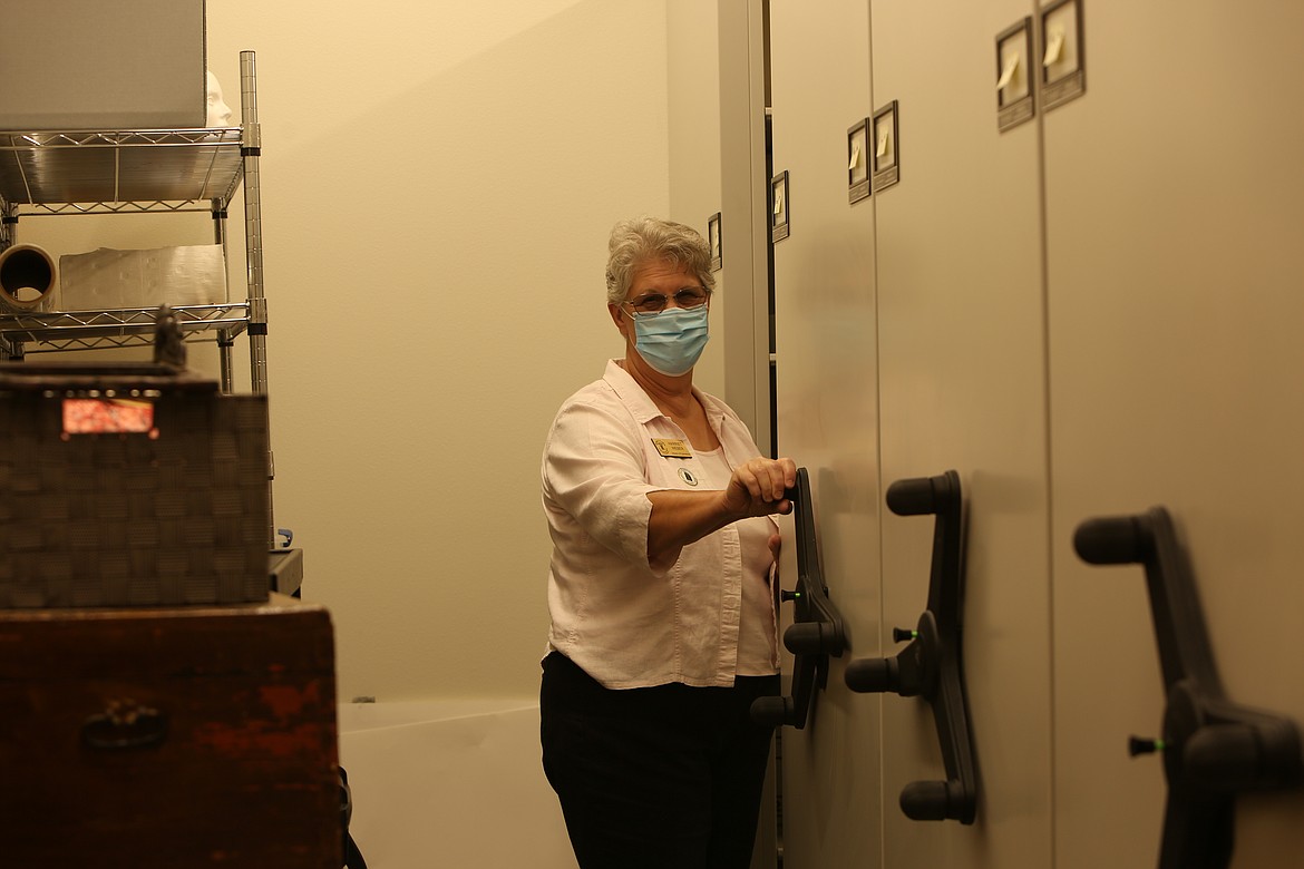 Director of Operations Harriet Weber works the accordion shelving units that house much of the Quincy Valley Historical Society's archives, including many objects that are 100 years old or older.