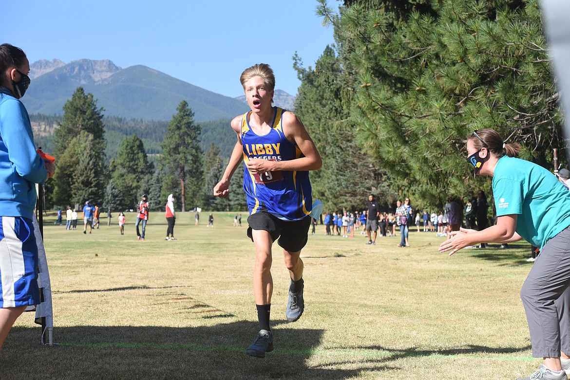 Dawson Rose, a junior on Libby High School men's varsity cross country team, bounds across the finish line at the Libby Invitation meet held at Cabinet View Golf Course Aug. 29.