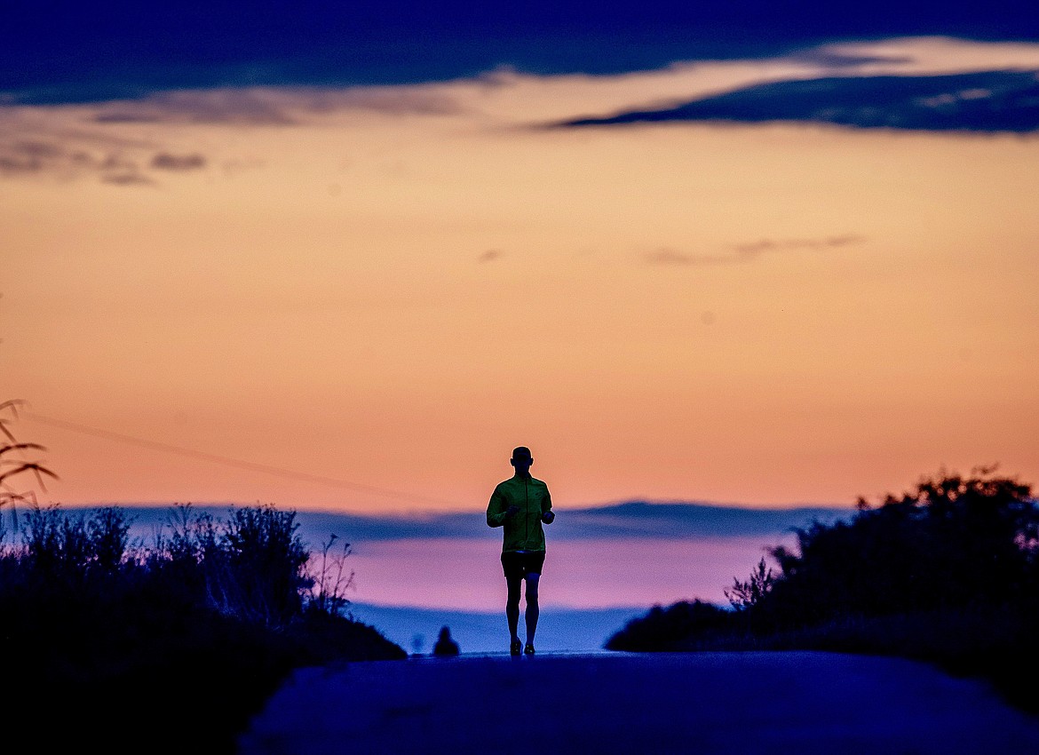 A man runs on a small road in the outskirts of Frankfurt, Germany, before sunrise on Tuesday, Sept. 1, 2020. (AP Photo/Michael Probst)