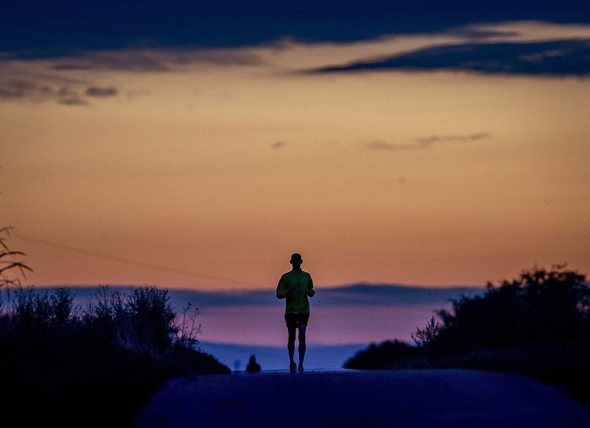 A man runs on a small road in the outskirts of Frankfurt, Germany, before sunrise on Tuesday, Sept. 1, 2020. (AP Photo/Michael Probst)