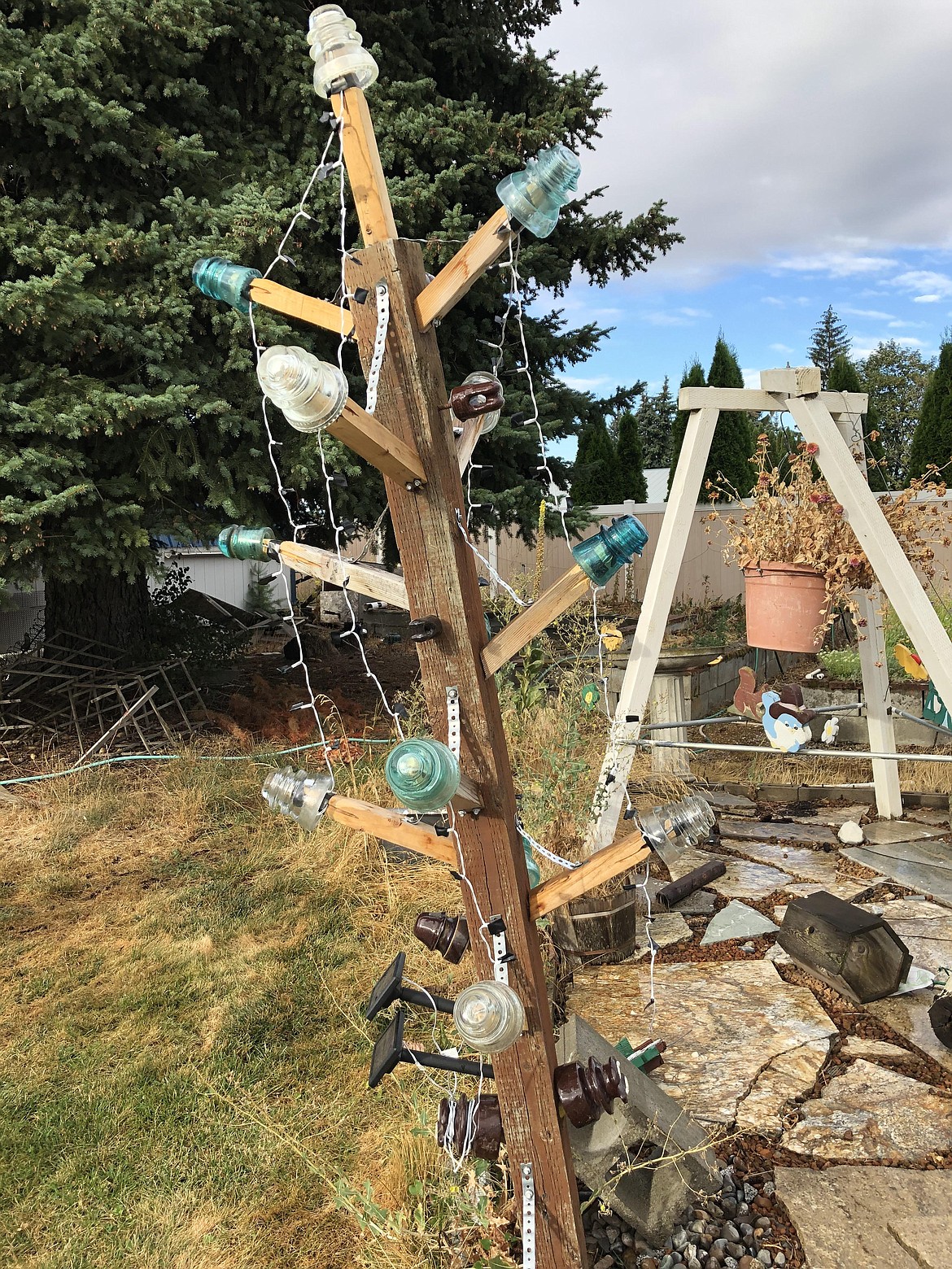 Not your typical Christmas tree, but it works: Solar-powered lights and old telephone line insulators glow in the dark.