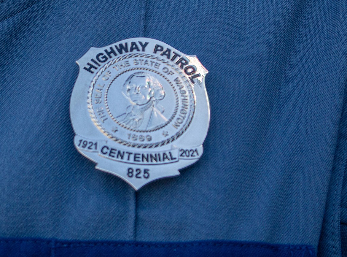 Trooper Jason Valentine dons the new commemorative "Centennial Badge" on Wednesday afternoon. The badge has the same design of those worn by the original 16 patrolmen who began the Washington State Patrol in 1921.