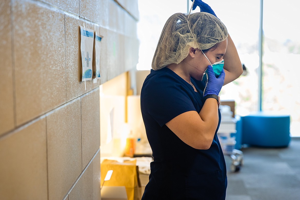 Nurse Kaydah Parker carefully removes her N-95 respirator within the doffing area (special area for removing PPE safely). There is a specific order in which all equipment is removed and then discarded or cleaned.