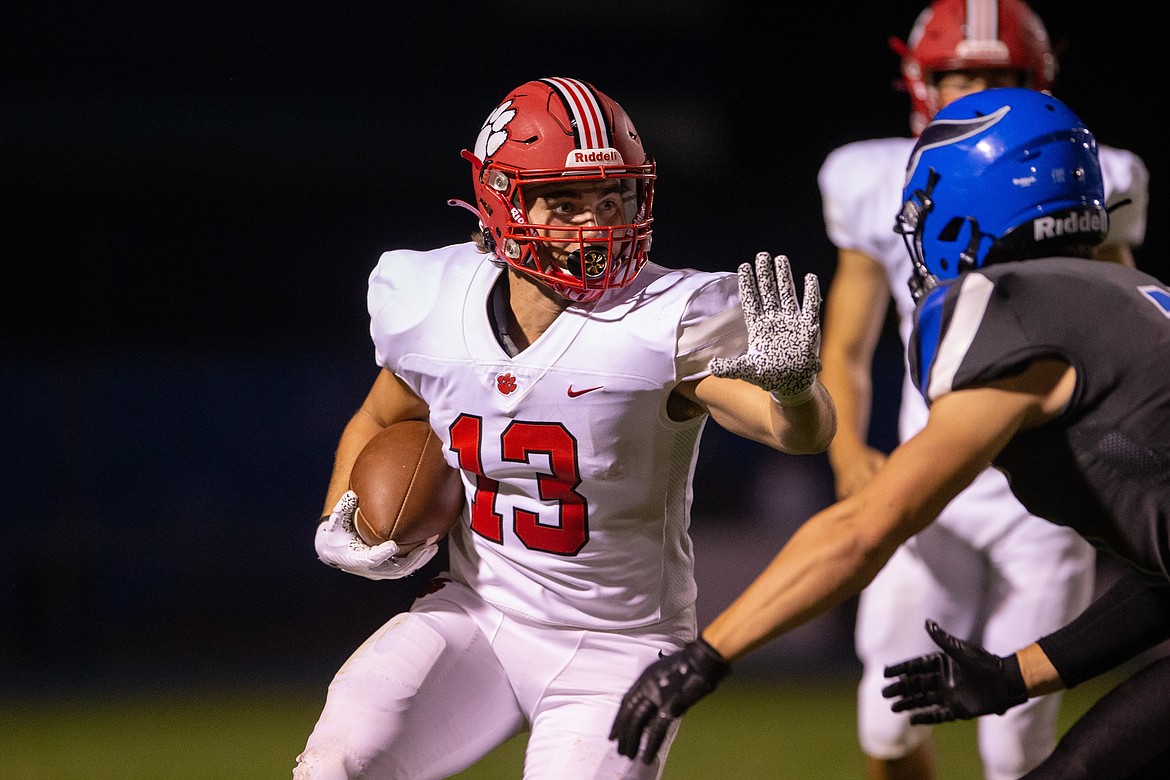 Junior running back Gerrit Cox prepares to stiff arm a Coeur d'Alene defender during Friday's game.