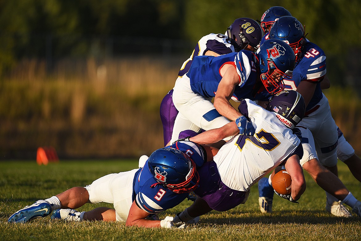 Bigfork’s Levi Taylor (3), Jackson Abney (21) and Isaac Bjorge (42) team up to bring down Cut Bank wide receiver Matt Larson (7) in the second quarter at Bigfork High School on Friday. (Casey Kreider/Daily Inter Lake)