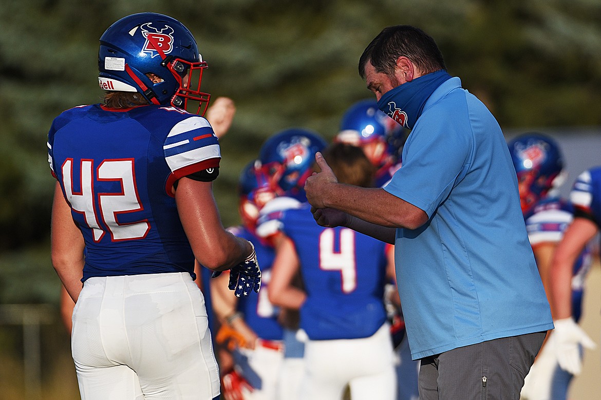 Bigfork head coach Jim Benn talks over a play with defensive end Isaac Bjorge (42) as they play Cut Bank at Bigfork High School on Friday. (Casey Kreider/Daily Inter Lake)