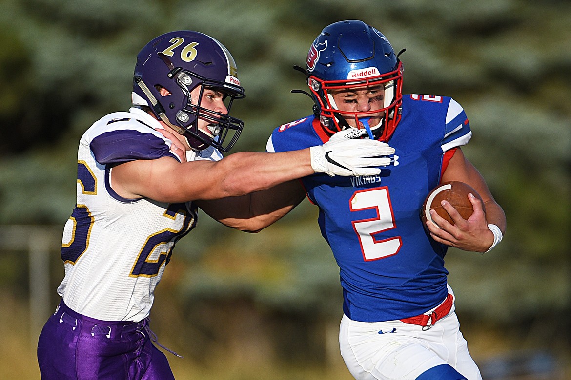 Bigfork quarterback Patrick Wallen (2) extends a stiff-arm to Cut Bank linebacker Hayden Hedges (26) during the first quarter at Bigfork High School on Friday. (Casey Kreider/Daily Inter Lake)