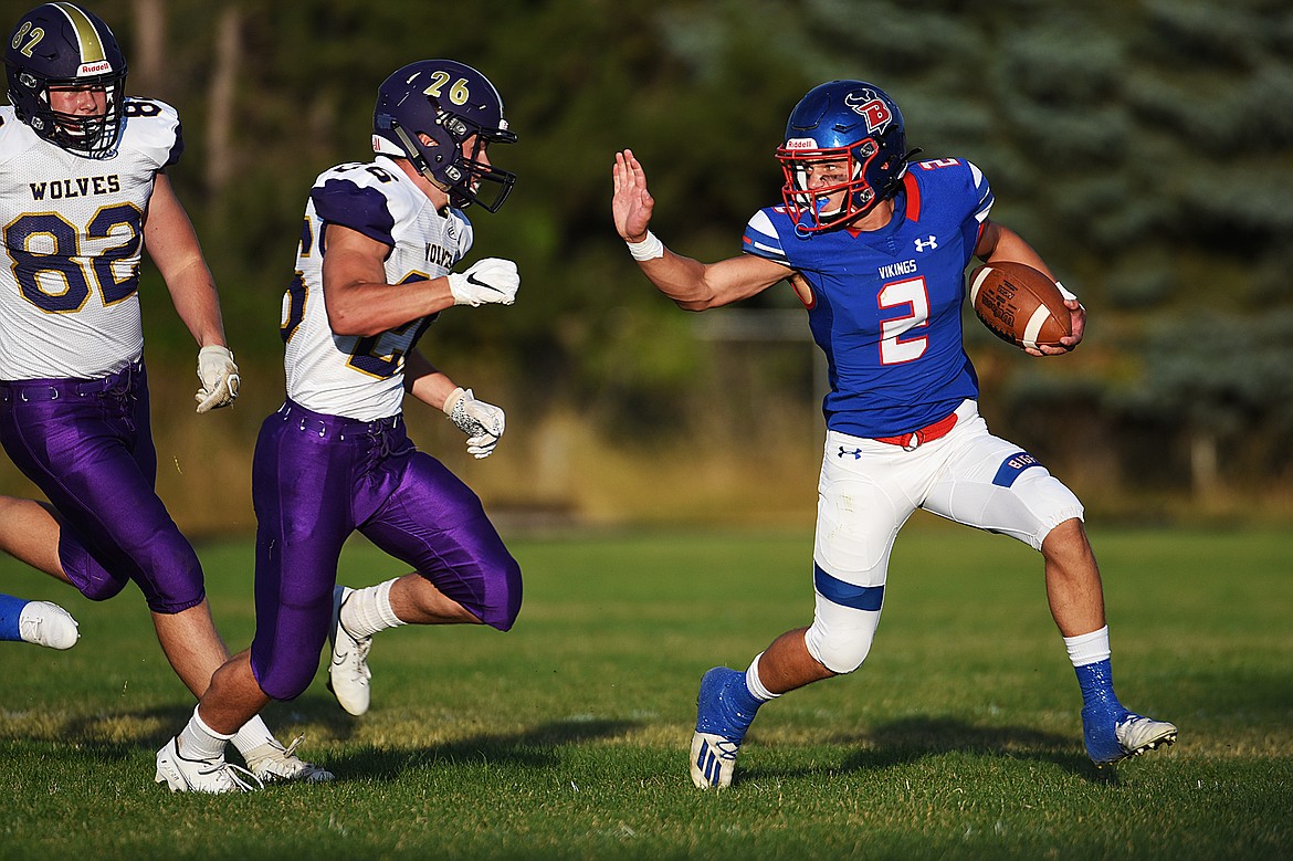 Bigfork quarterback Patrick Wallen (2) extends a stiff-arm to Cut Bank linebacker Hayden Hedges (26) during the first quarter at Bigfork High School on Friday. (Casey Kreider/Daily Inter Lake)