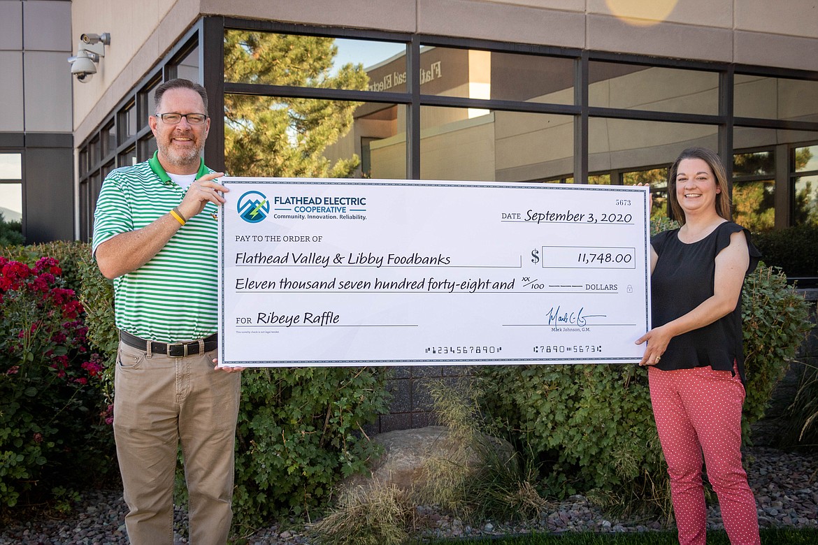 Flathead Electric Cooperative's general manager Mark Johnson presents a check to Jamie Quinn, director of the Flathead Food Bank. Proceeds from the co-op's Ribeye Raffle will be distributed to all the food banks in its service territory, which includes Libby.