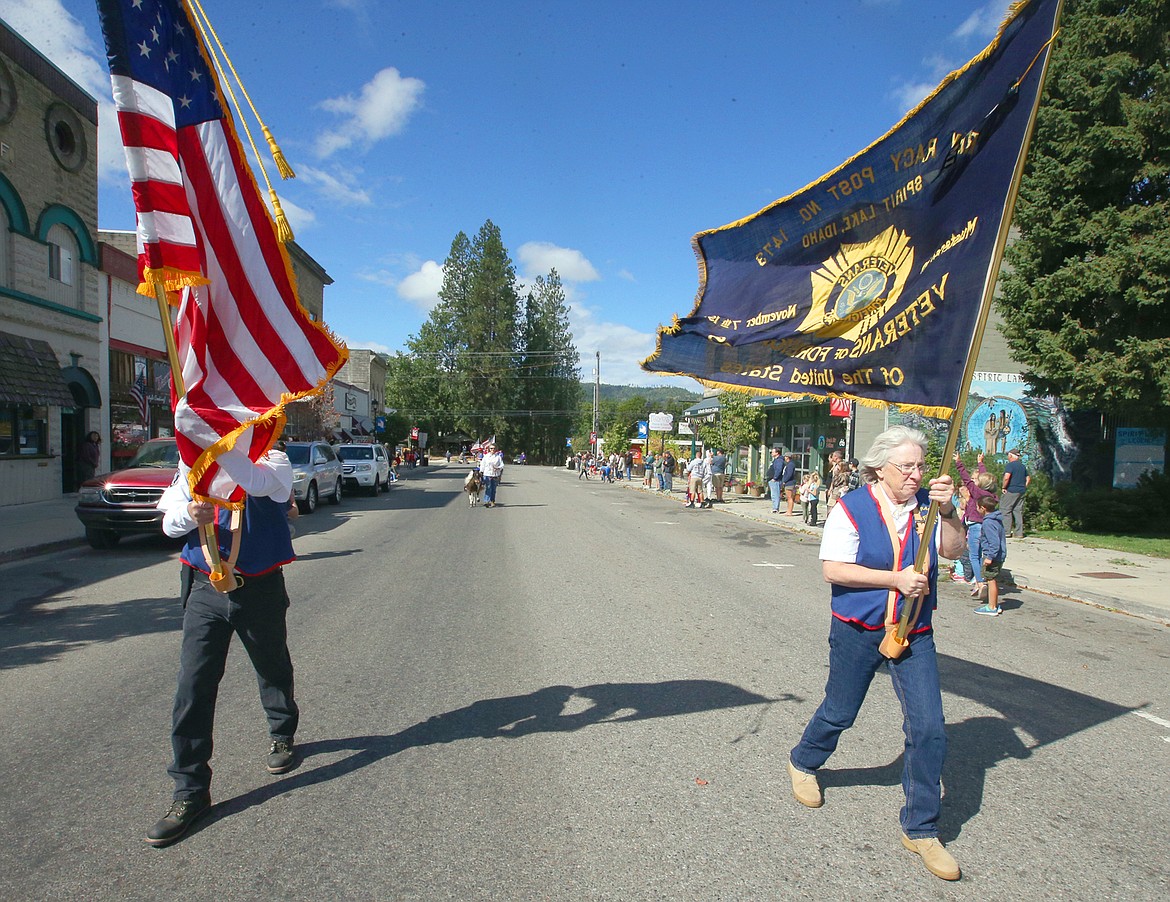 VFW Post 1473 Commander Gary Stairs and Quarter-master Terrie Hauck carry flags to lead the Labor Day parade in Spirit Lake.