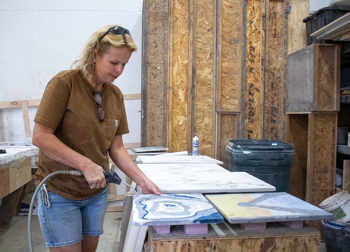 Christina Arnall sprays off one of her ongoing concrete works inside her concrete studio in Quincy on Wednesday, Sept. 9. Arnall said that area of her business with D.C. Custom Construction Inc. has grown significantly in popularity in just the last year.