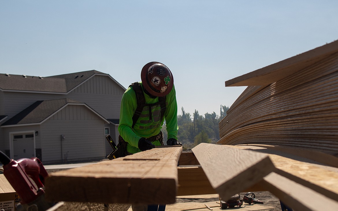 Gustavo Silva, with Hayden Homes, trims a piece of wood to fit as construction work continues in the developing Sagecrest neighborhood in Moses Lake on Thursday, Sept. 10.