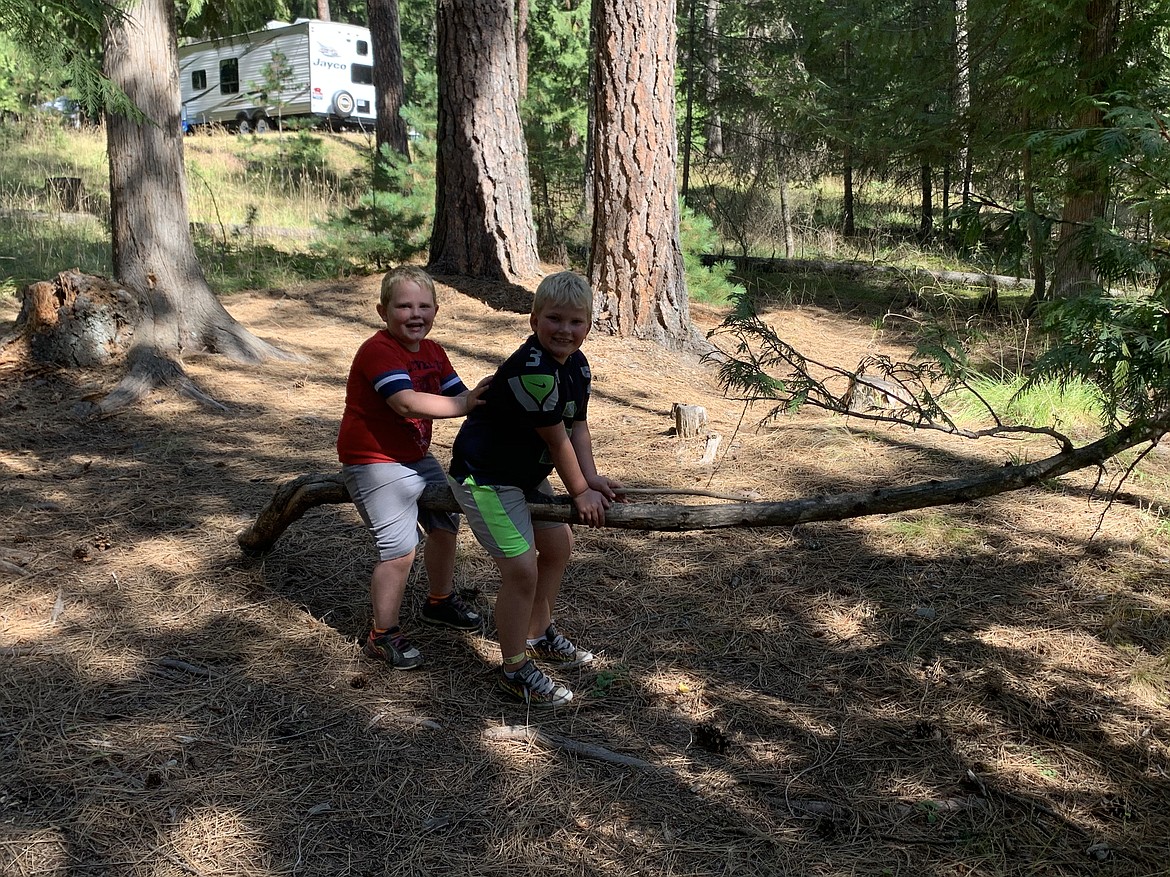 Mason, left, and Jordan Main pose for a photo on Sunday at their grandparent's, Jerry and Colleen Flowers' campsite not too far from where the first tree landed on the firepit.