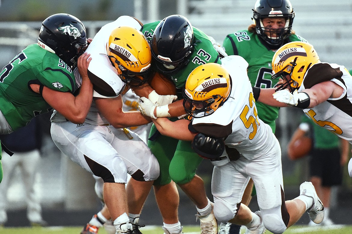 Glacier running back Jake Rendina (33) is wrapped up by Helena Capital defenders in the first half at Legends Stadium on Friday. (Casey Kreider/Daily Inter Lake)