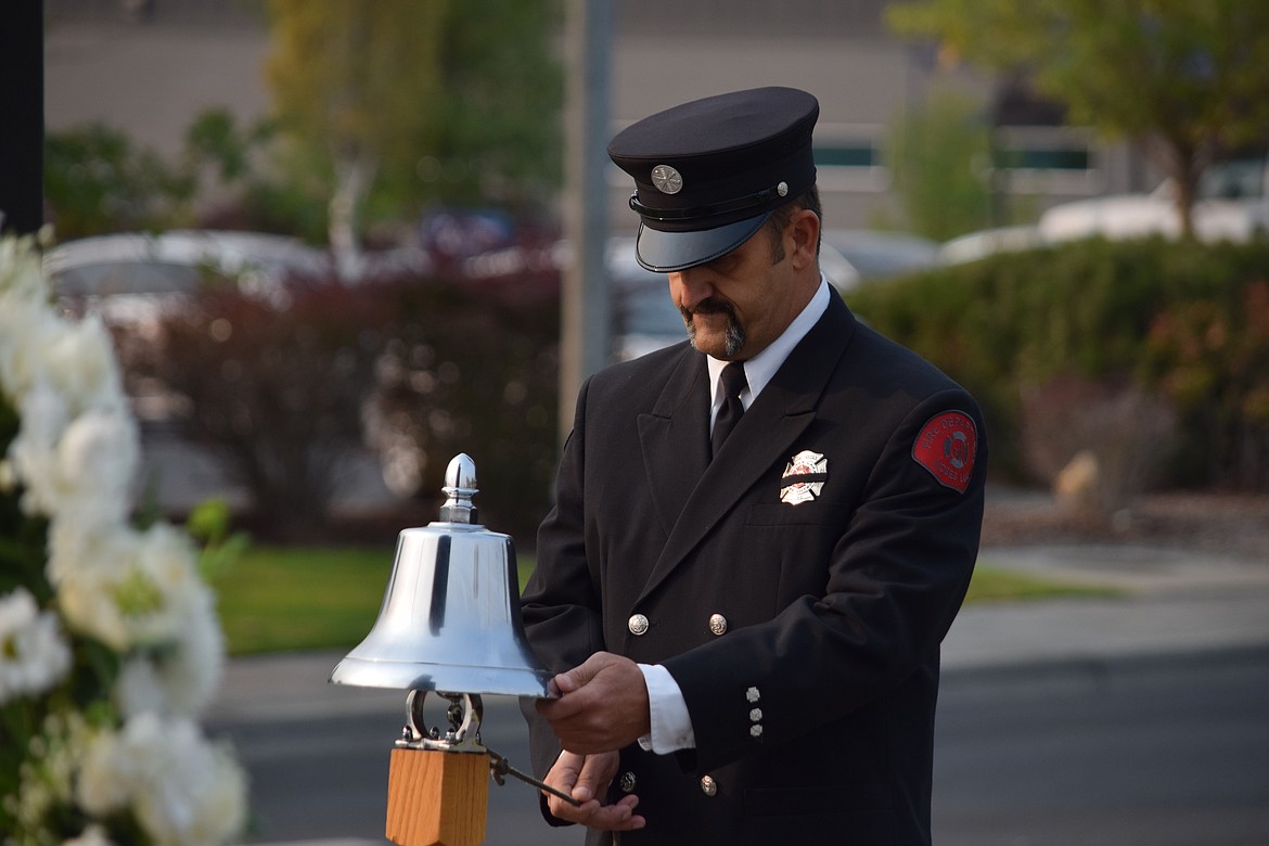 Moses Lake firefighter Jason Koziol rings in the "four fives" to honor the New York City firefighters who died in the attack on the World Trade Center on Sept. 11, 2001, as part of the annual Moses Lake Patriot Day remembrance ceremony Friday morning.