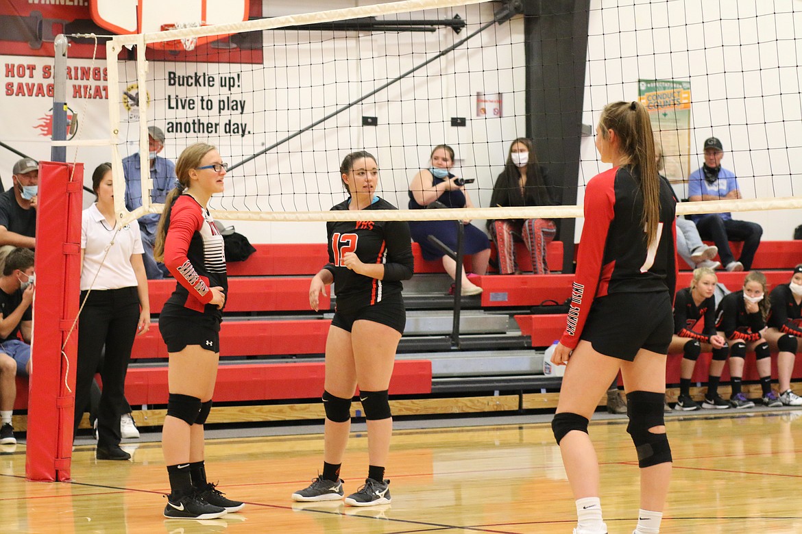 From left, Lizzy Fisher (HS), Madison Elliot (Plains 12) and Katelyn Christensen 7 (HS) have a light moment between serves. (Chuck Bandel/Valley Press)