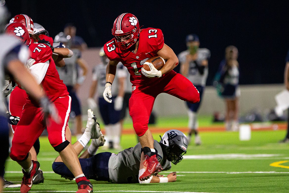 Junior running back Gerrit Cox leaps over a Lake City defender during Friday night's game.