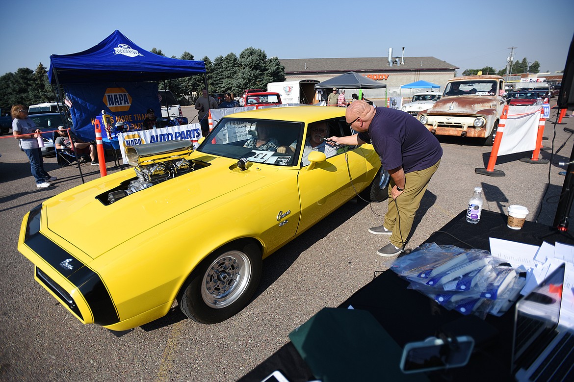 Monte Klindt, right, co-owner of Performance Heating & Air in Evergreen and a co-organizer of Kruise Kalispell, speaks with Donny Stevens as he drives his 1968 Chevrolet Camaro SS through the Evergreen Show ’N Shine virtual car show at Conlin’s Furniture on Saturday.  (Casey Kreider/Daily Inter Lake)
