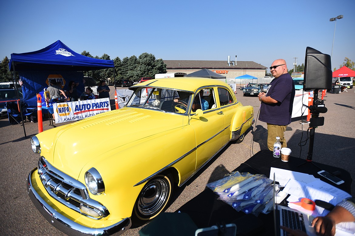 Monte Klindt, right, co-owner of Performance Heating & Air in Evergreen and a co-organizer of Kruise Kalispell, speaks with Don Kennedy as he drives his 1952 Chevrolet Deluxe through the Evergreen Show ’N Shine virtual car show at Conlin’s Furniture on Saturday.  (Casey Kreider/Daily Inter Lake)