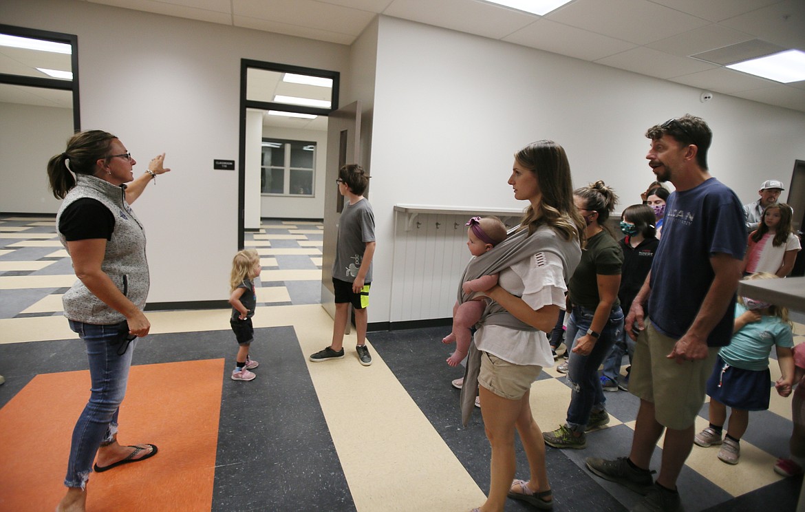 Amy Thompson, board chair for Hayden Canyon Charter, guides families through the hallway as they check out classrooms in the new school Friday evening.