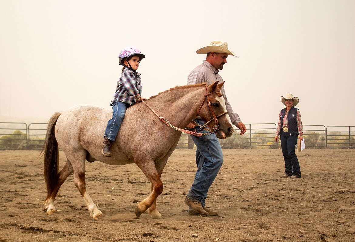 Savanna Allen is accompanied by her father as she makes her way around G & C Arena during competition at the Buckle Series event on Saturday, Sept. 12.