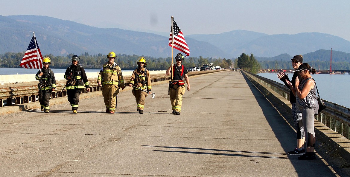 Eagle Schacht, Timo Schact, Cecil Jensen, Grant Bansemer, and Austin Theander are applauded as they walk across the Long Bridge to pay tribute to those injured and lost in the Sept. 11, 2001, terrorist attacks in New York City, Arlington, Va., and Shanksville, Pa.