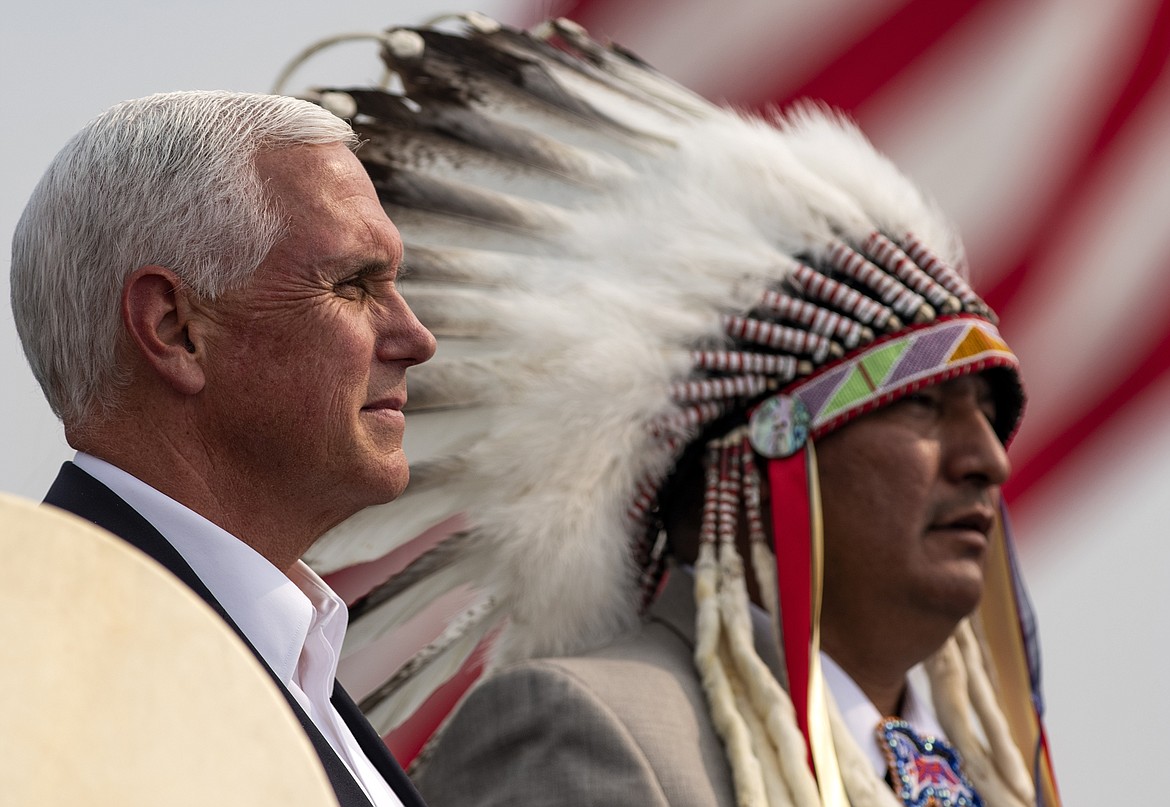 Vice President Mike Pence watches as the members of the Crow Indian Reservation honor him during a Republican campaign rally in Belgrade, Mont., on Monday, Sept. 14, 2020. (AP Photo/Tommy Martino)