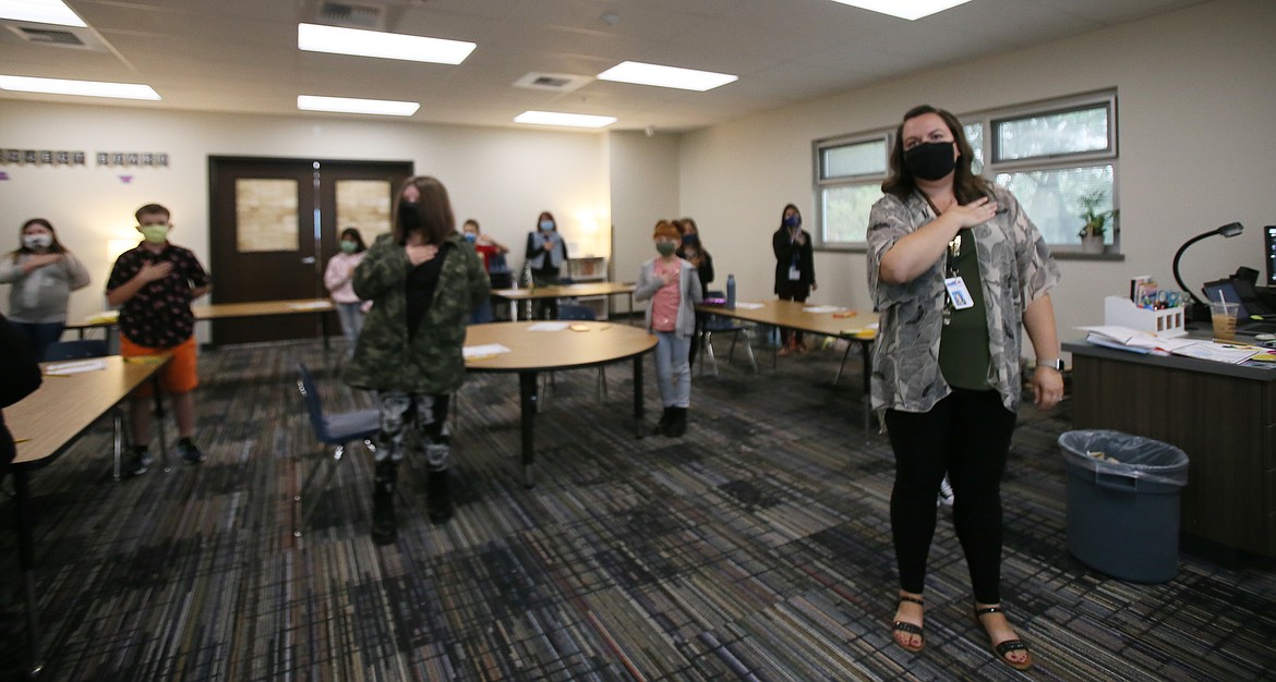 Fourth grade teacher Jessica Johnson, right, leads her class in the Pledge of Allegiance on the first day of school Monday at the new Northwest Expedition Academy on Prairie Avenue.