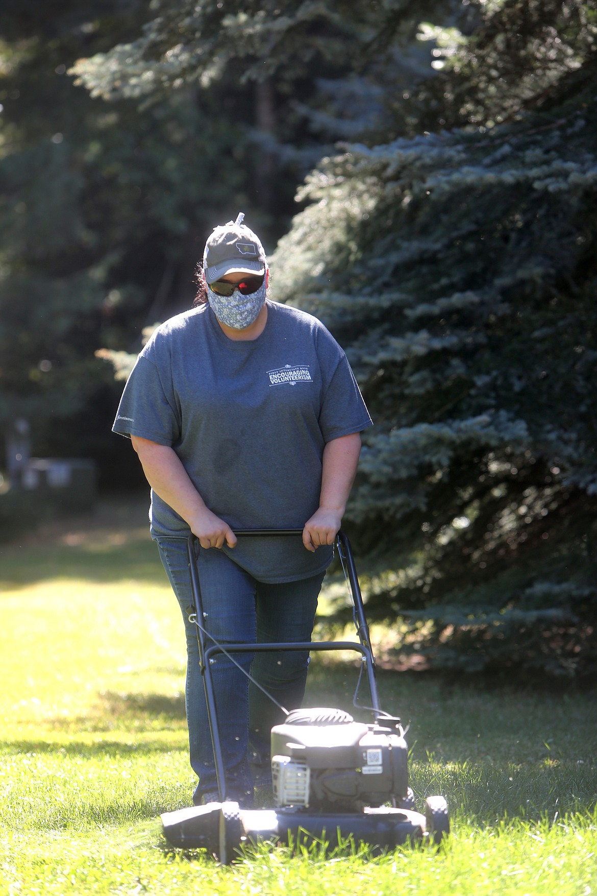 First Interstate Bank financial service representative Becca Brandewie mows grass outside of  a Bigfork residence during First Interstate's volunteer day, Sept. 9. Last Wednesday, all First Interstate locations closed at noon to allow employees to spend the afternoon volunteering in their local community. Employees with the Bigfork branch partnered with My Glacier Village and did chores for local seniors. (Mackenzie Reiss/Bigfork Eagle)