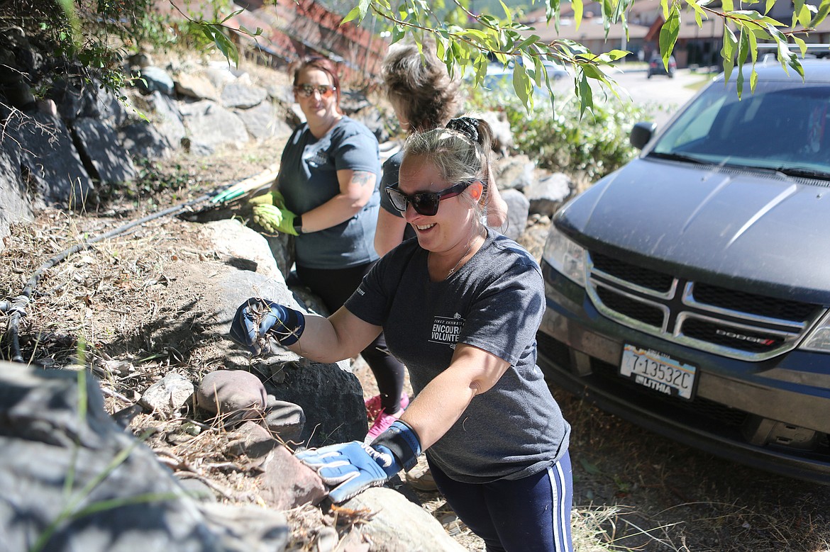 First Interstate Bank teller Jocelyn Holloway clears debris at the ACES After School program's new location on Commerce Street. (Mackenzie Reiss/Bigfork Eagle)