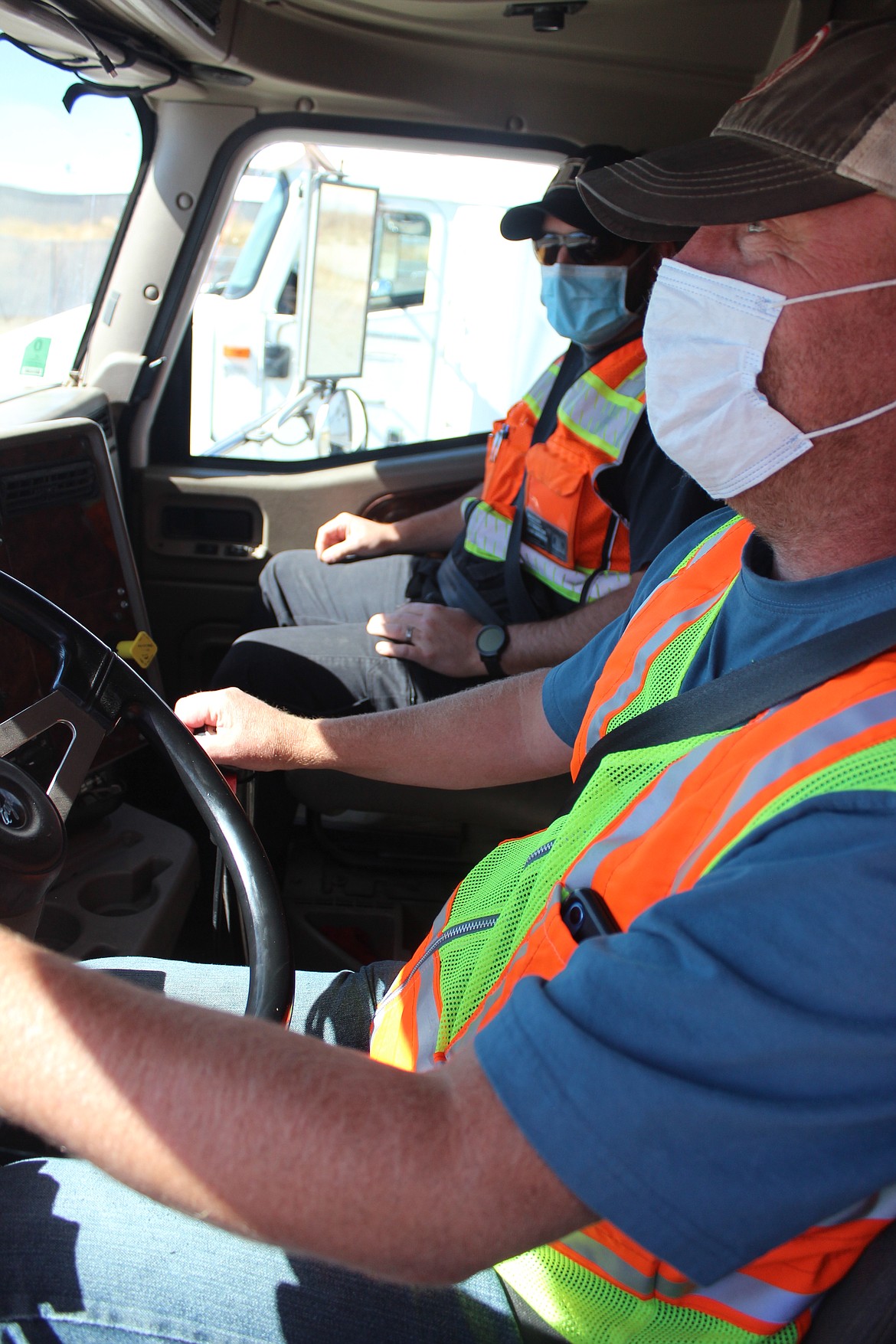 Bruce Nordstrom (foreground), of Coeur d’Alene, learns gear shifting in the cab from North Idaho College/Drive509 CDL Instructor Josh Munderloh. Wearing masks while inside the cab allows the course to be taught safely and in accordance with state guidelines.