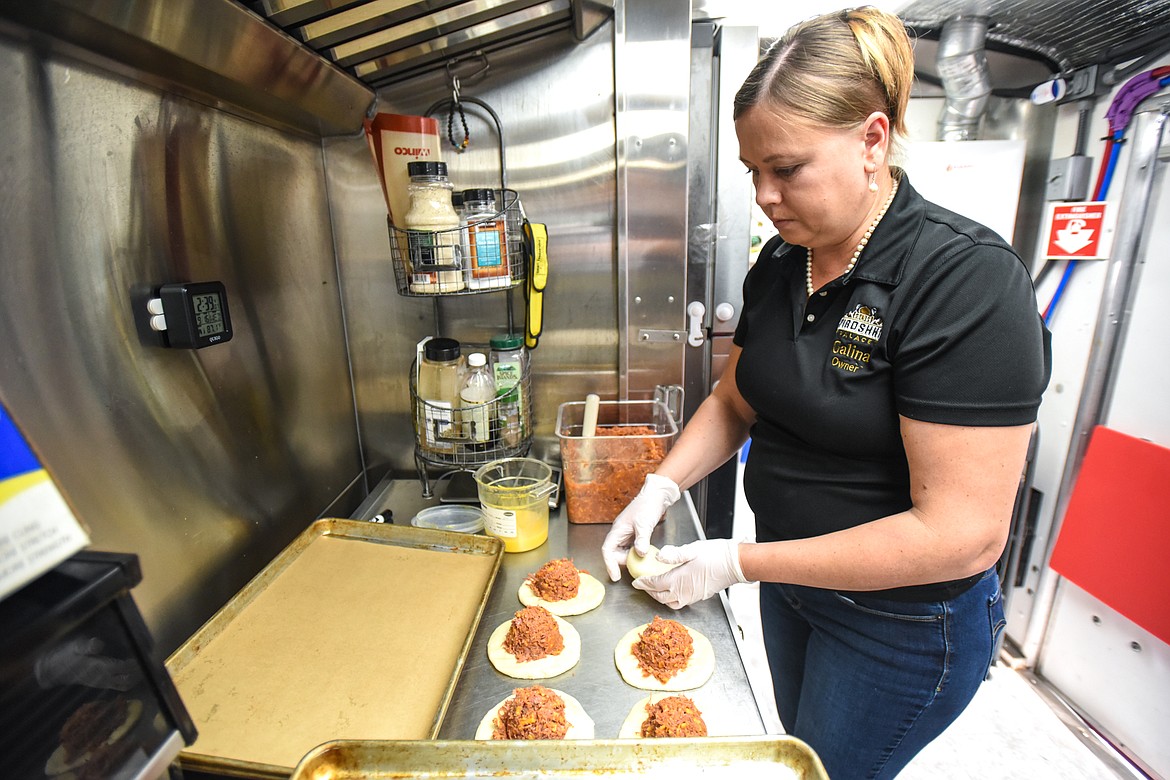 Galina Mays works on pulled pork piroshki inside the Piroshki Palace food truck on Wednesday, Sept. 16. (Casey Kreider/Daily Inter Lake)