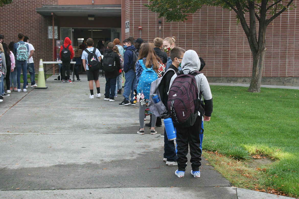 Frontier Middle School students wait in line at a screening station on the first day of in person instruction in Moses Lake Thursday.