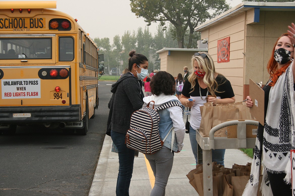 A Garden Heights Elementary student and her mom ask directions to a screening station Thursday. It was the first day of in-person instruction in the Moses Lake School District.