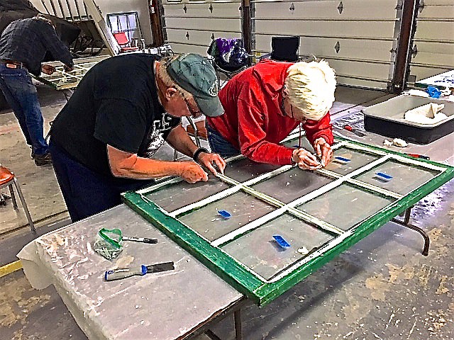 Mark and Karen Sheets work refurbishing the original windows from the Mount Wam Lookout in the Kootenai National Forest. (photo provided)