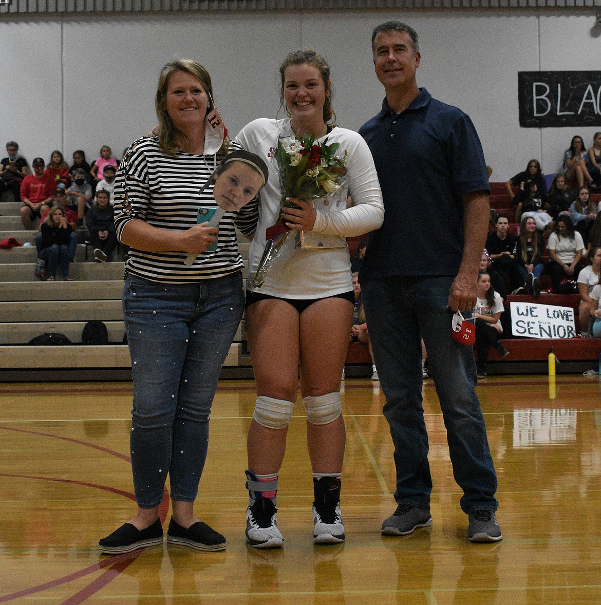 Katie Stewart poses for a photo with her family on a Senior Night.