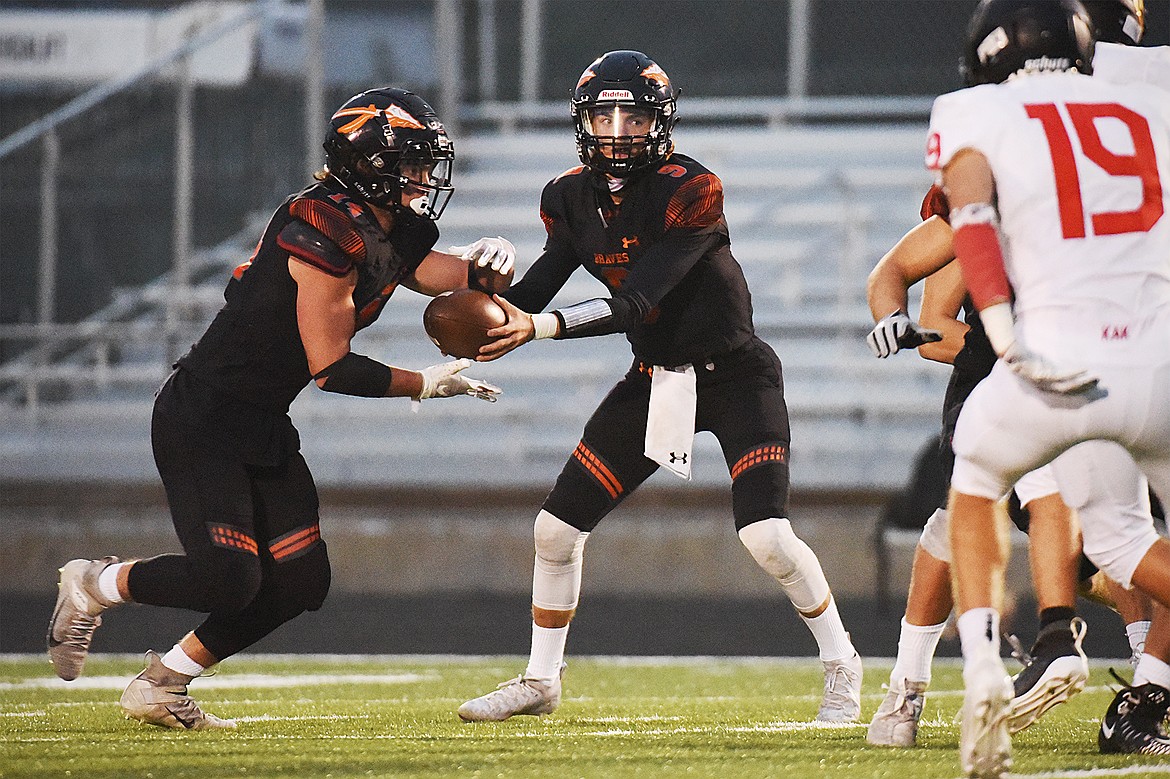 Flathead quarterback Charlie Hinchey (9) hands off to running back Alec Thomas (14) in the second quarter against Missoula Hellgate at Legends Stadium on Friday. (Casey Kreider/Daily Inter Lake)