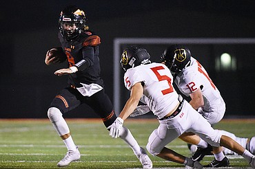 Flathead quarterback Charlie Hinchey (9) scrambles for a gain in the second quarter against Missoula Hellgate at Legends Stadium on Friday. (Casey Kreider/Daily Inter Lake)