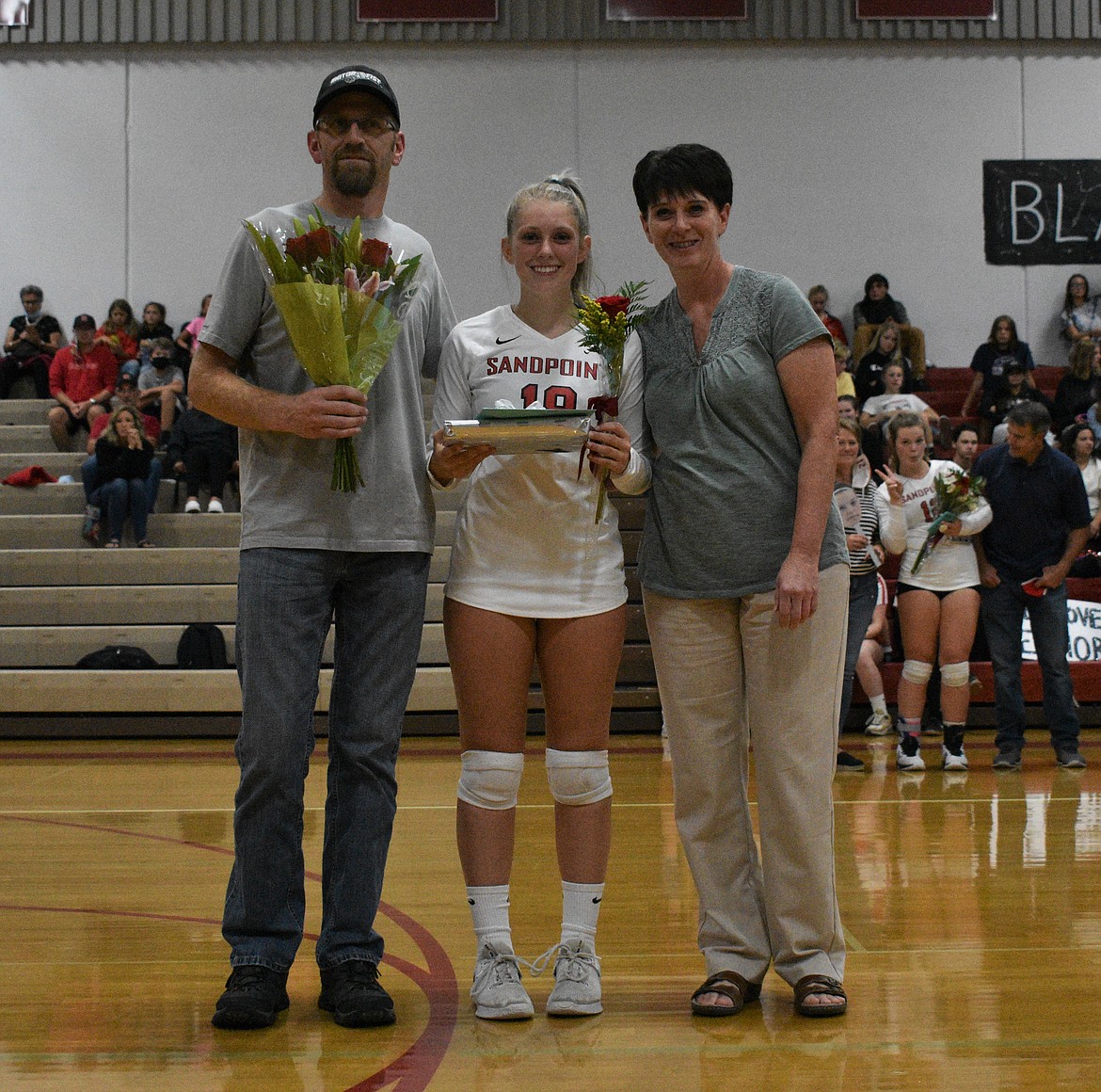 Sam Koster poses for a photo with her family on a Senior Night.