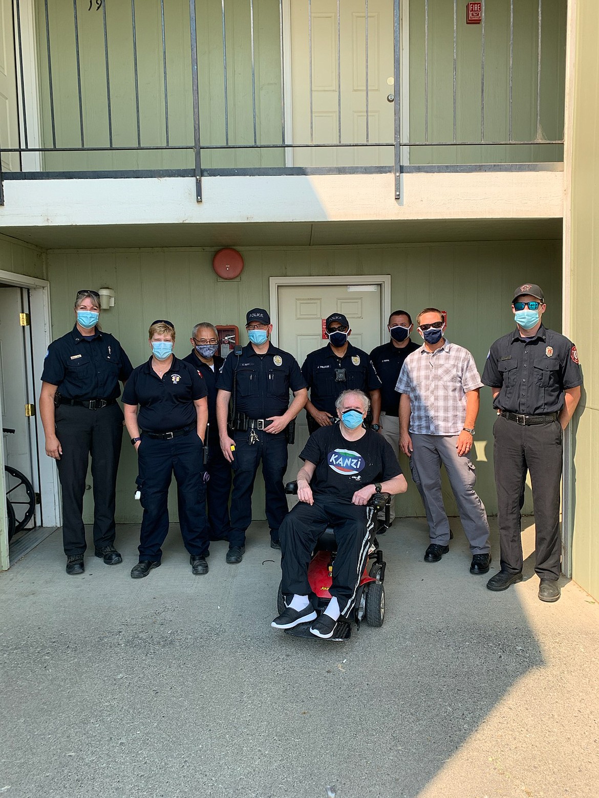 Left to right, Firefighter Michele Talley, EMT Julie Gillespie, EMT Gabe VanKempen, Officer Chris Doty, Sgt. Jorge Trujillo, Officer Gary Amaral, Detective Steven Harder and Firefighter Mike Ryan pose with Quincy resident Dave Stratton, front, after coming together to assist Stratton with purchasing new batteries and a charger for his battery-operated wheelchair last week.