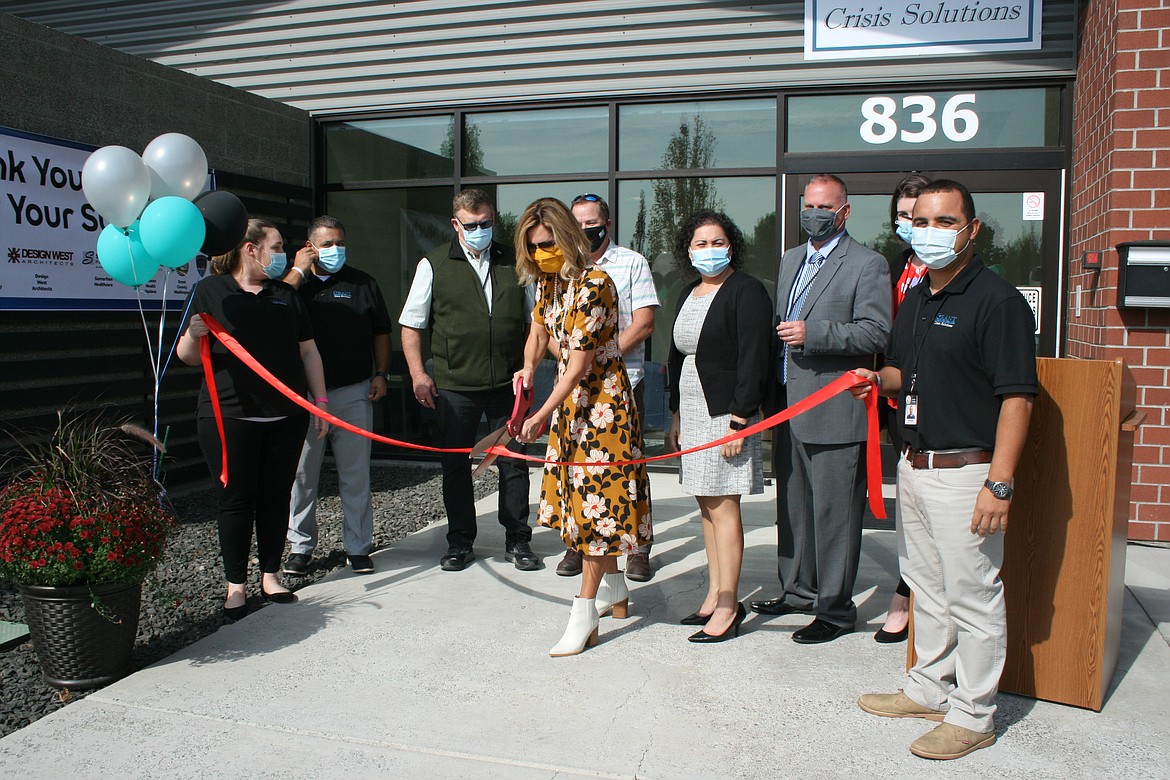 Grant County Commissioner Cindy Carter prepares to cut the ribbon at the new Crisis Solutions Center Monday. Also on hand were (from left) crisis center manager Traci Hunt, Grant Integrated Services quality manager Mike Lopez, Grant County Commissioners Richard Stevens and (behind Carter) Tom Taylor, GIS chief financial officer Veronica Perez, GIS executive director Dell Anderson, executive assistant Linze Greenwalt and crisis center supervisor Anselmo Quezada. 
The facility will provide short-term treatment to people facing a mental health crisis.