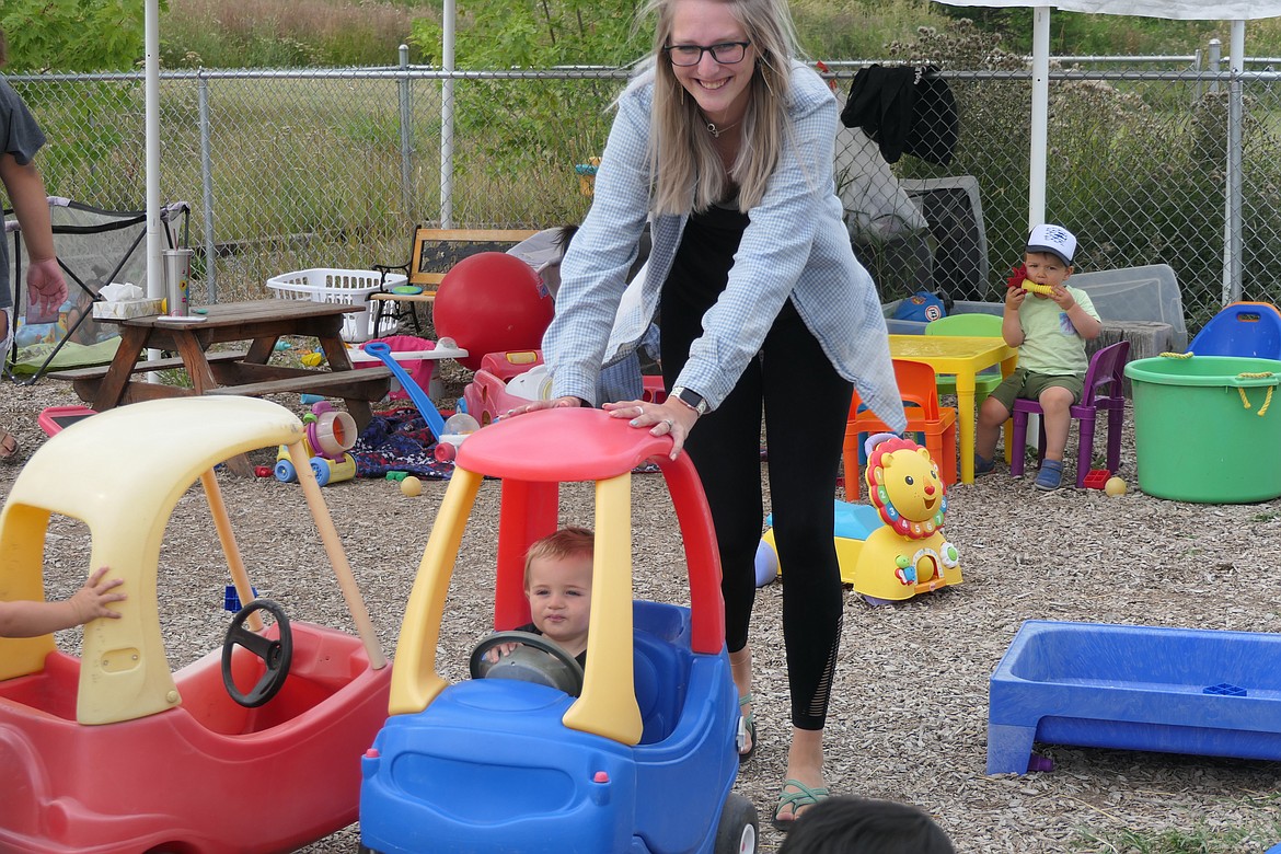 Fun is all part of the learning at Fun and Fancy Free Learning Center. Lindsay Barber helps a toddler on his ride to the future. (Carolyn Hidy/Lake County Leader)