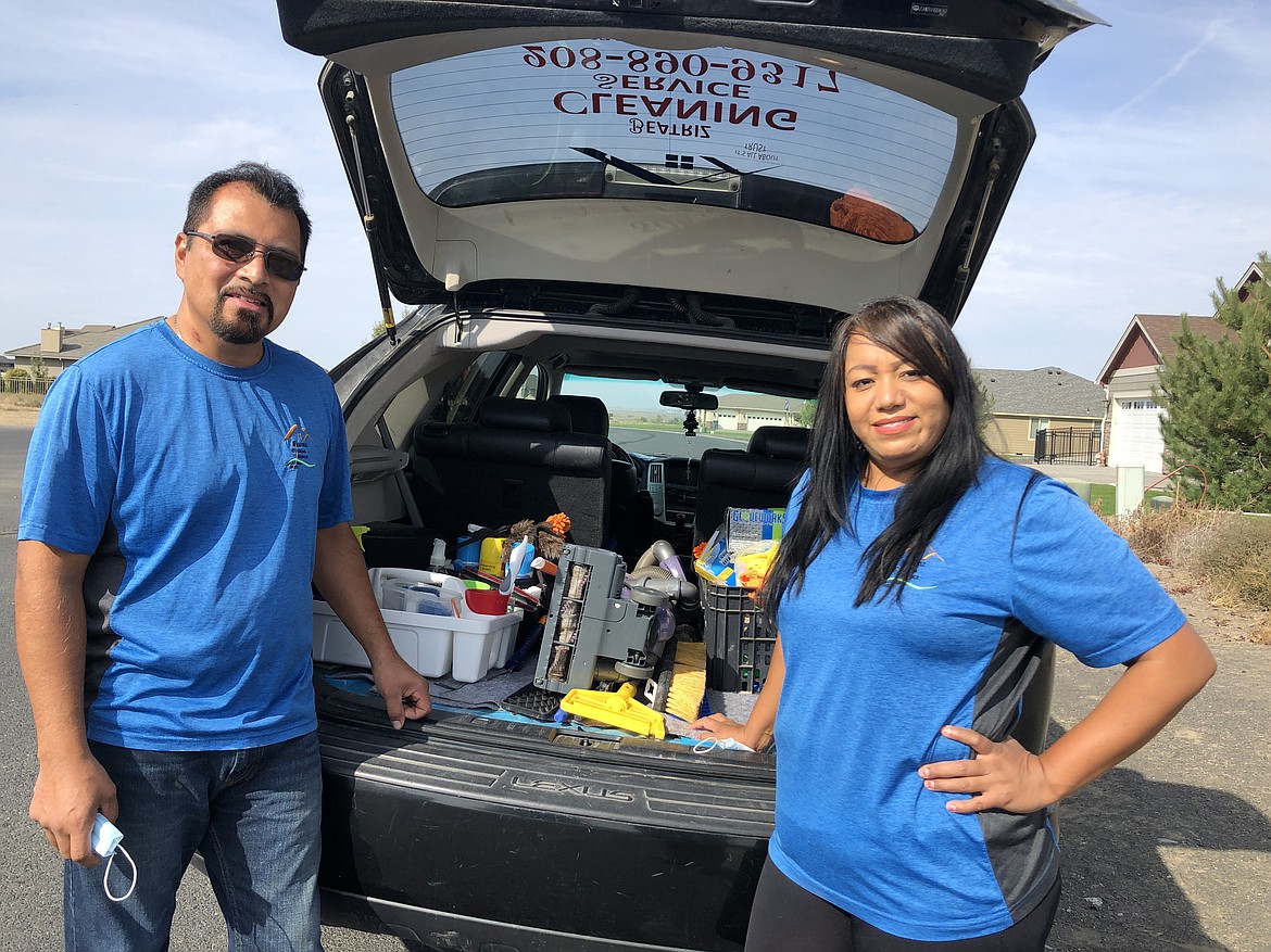 Angel and Beatriz Dominguez in front of their "office" as they get ready to clean a house on Monday.