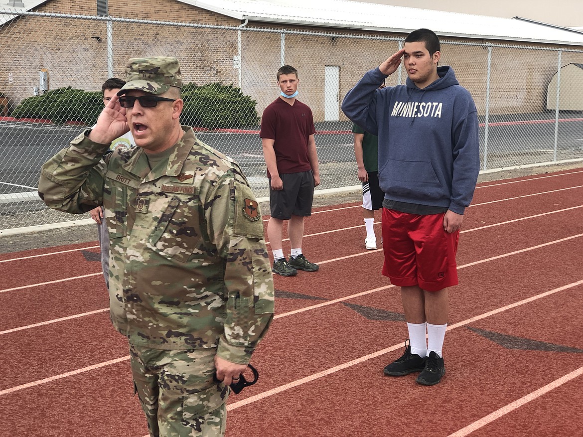 Air Force Senior Master Sgt. Will Britt uses MLHS senior Quinton Manning to demonstrate a proper salute during the first day of drills on Wednesday for the Moses Lake School District's new Air Force Junior ROTC program.
